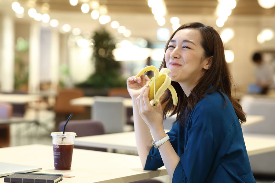 オフィスでバナナを食べる女性